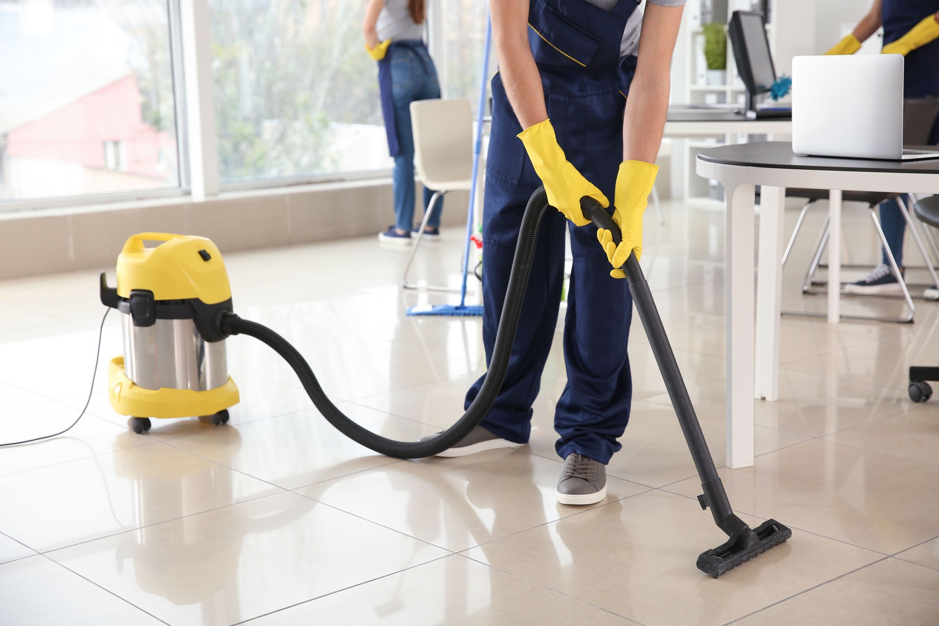 Conserje hoovering piso en oficina